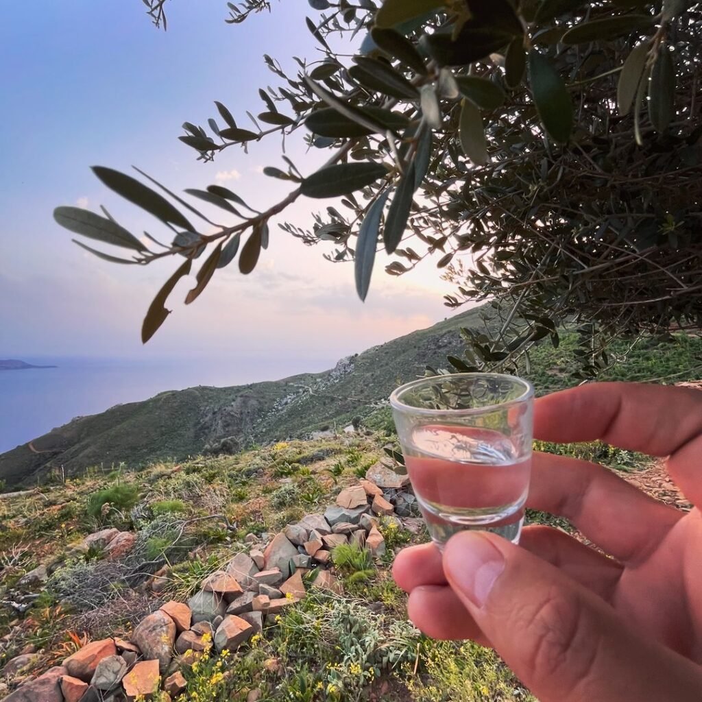 Cretan raki with the coast of Agia Galini in the background.