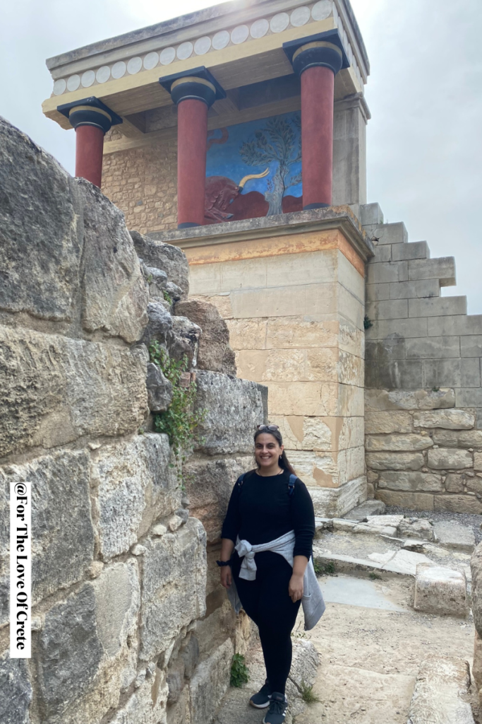 a woman standing in front of a stone building, Knossos Palace in Crete.