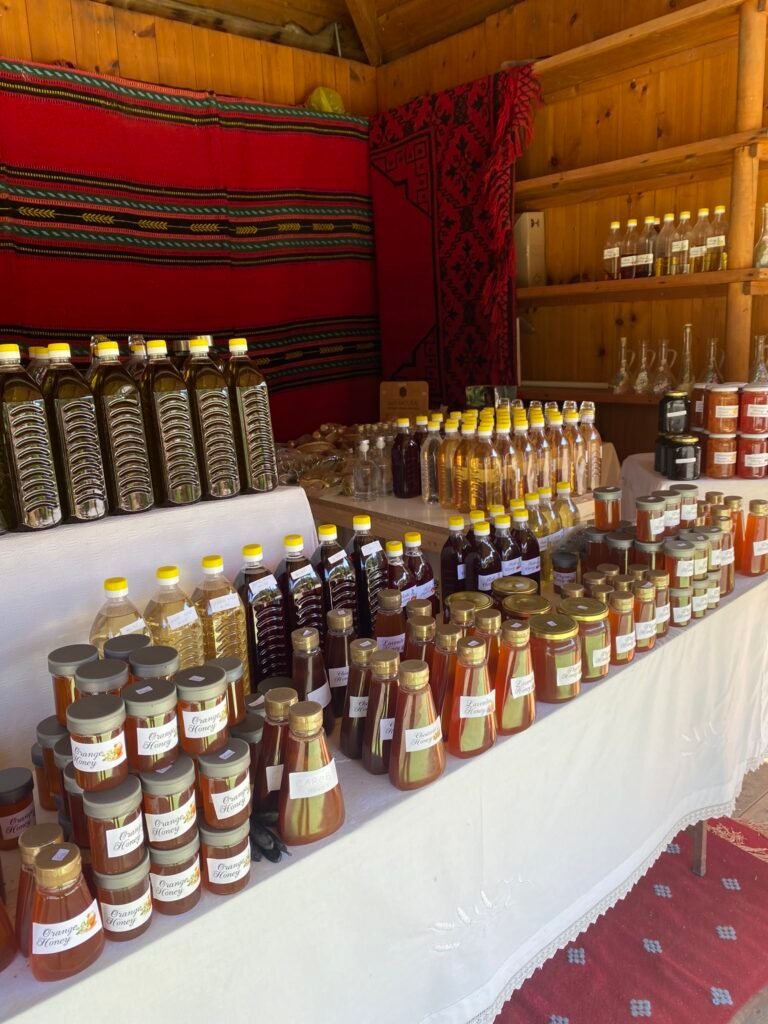 A charming roadside stall brimming with Cretan treasures: raki, honey, jams, and more, all celebrating the island's rich flavors and traditions.