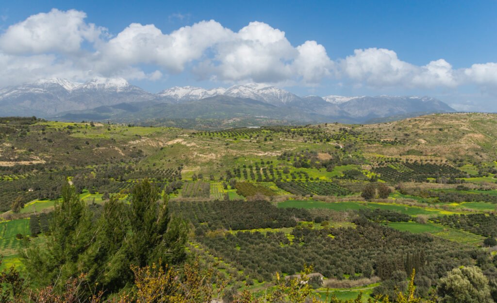 A breathtaking view of the Messara Plain with the snow-capped Mount Ida in the distance, as seen from Phaistos, Crete.