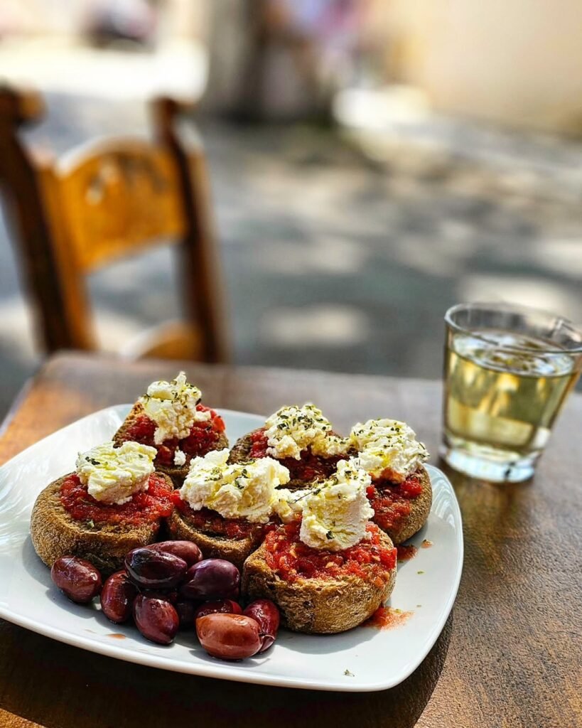 A classic Cretan delight, Dakos brings together barley rusks, fresh tomatoes, creamy myzithra cheese, and a generous drizzle of extra virgin olive oil. The perfect taste of Greek mezedes.