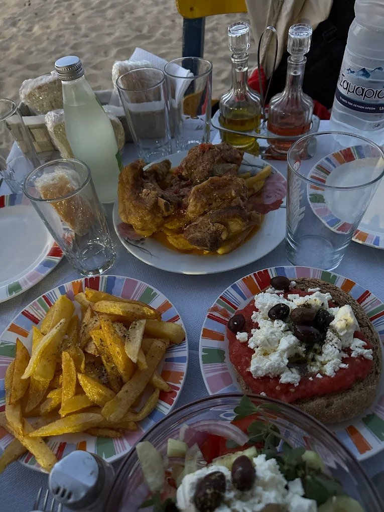 Local wine, dakos, and stewed goat—just another laid-back lunch at Four Brothers, where your toes are in the sand and your taste buds in heaven. 