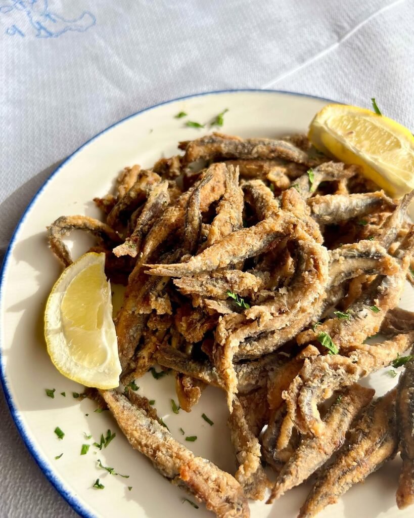 Perfectly crispy and full of flavor, these tiny fried fish (Gavros) are a seaside favorite, best eaten whole with a generous squeeze of lemon. 