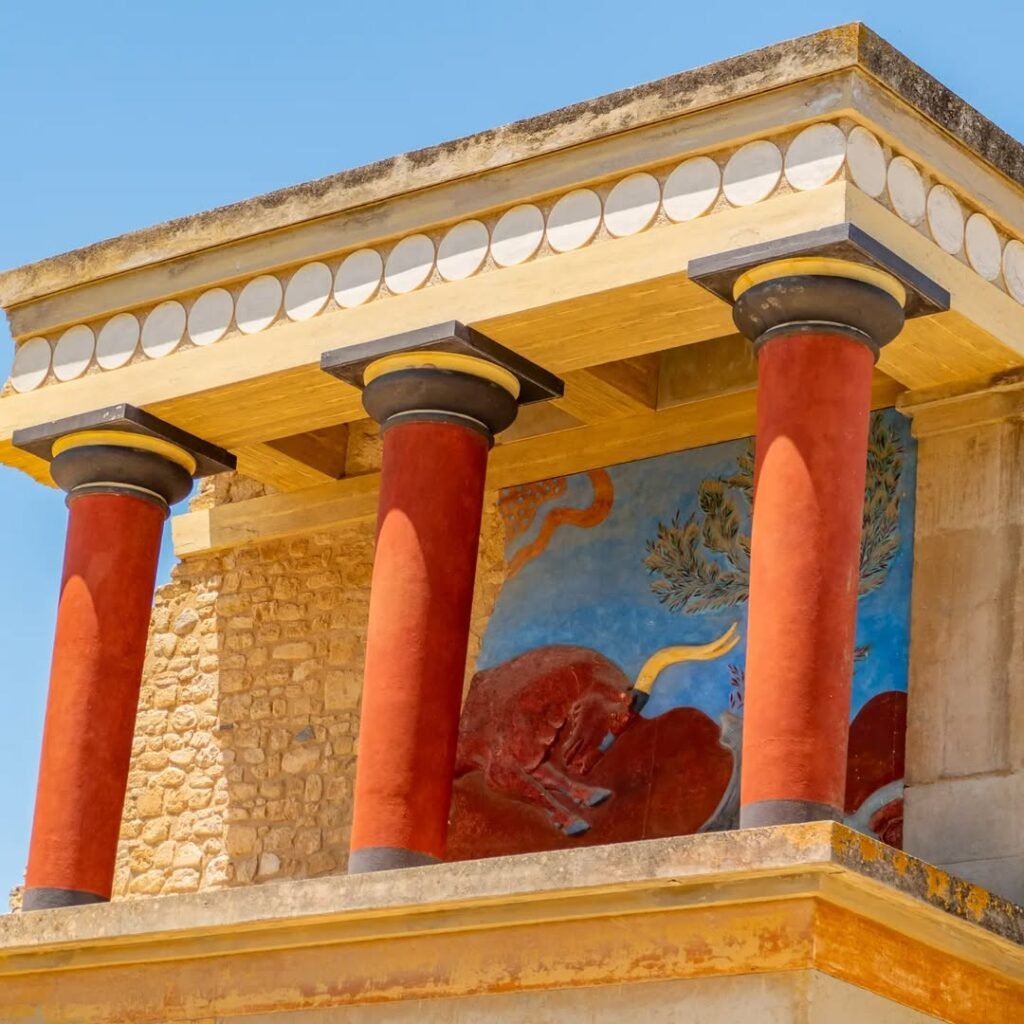 The iconic red columns of Knossos Palace showcase the distinctive Minoan architectural style and colorful frescoes that have drawn over one million visitors in 2024. This reconstructed section features the famous bull fresco, representing one of the most recognizable symbols of Europe's first advanced civilization.