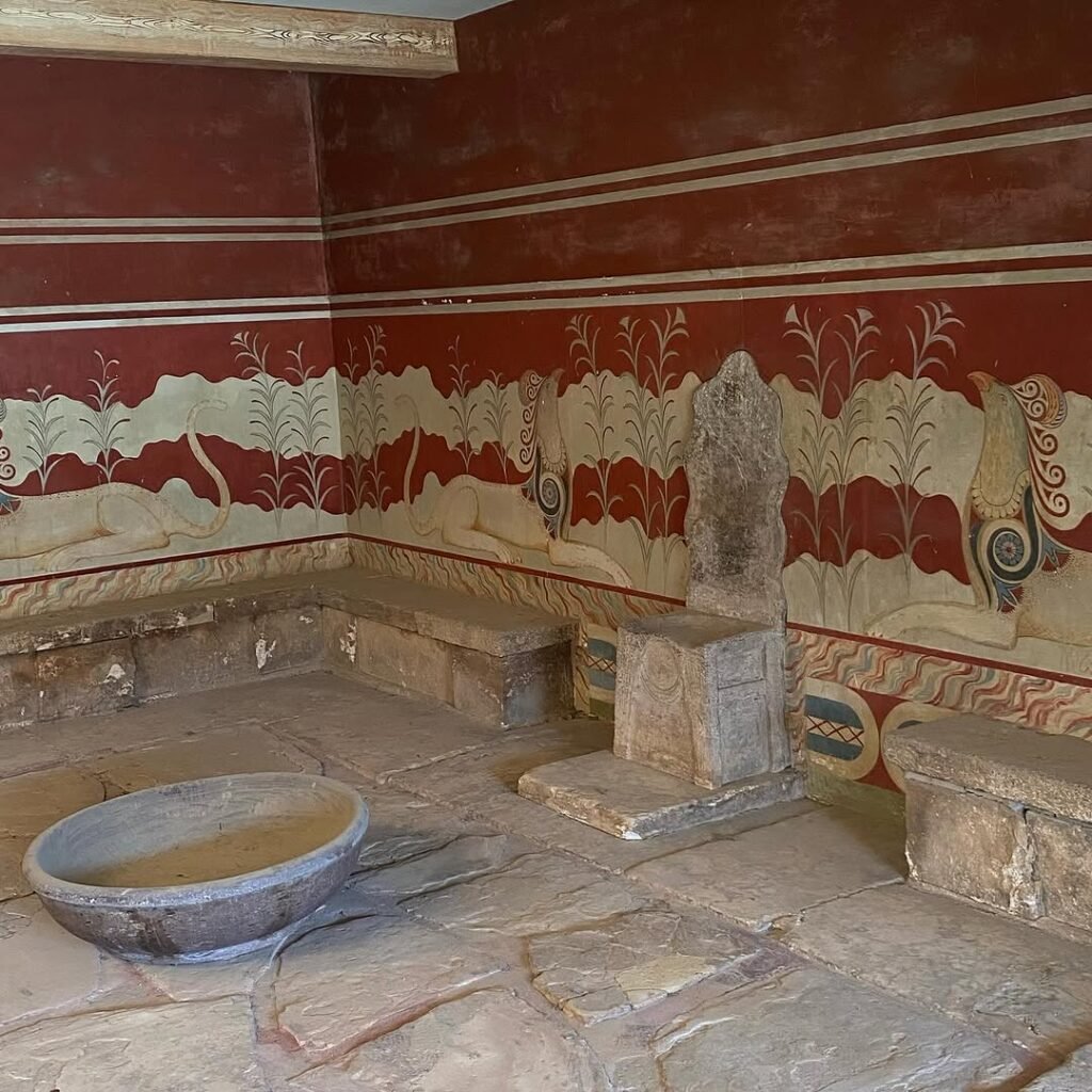 The legendary Throne Room at Knossos Palace, featuring the oldest throne in Europe, vibrant restored frescoes, and ceremonial basin.
