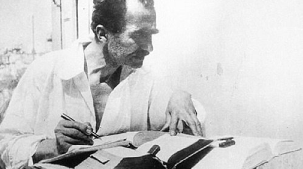 Nikos Kazantzakis, often regarded as a modern Greek philosopher, deep in thought as he writes—his works blending existentialism, spirituality, and the quest for freedom.