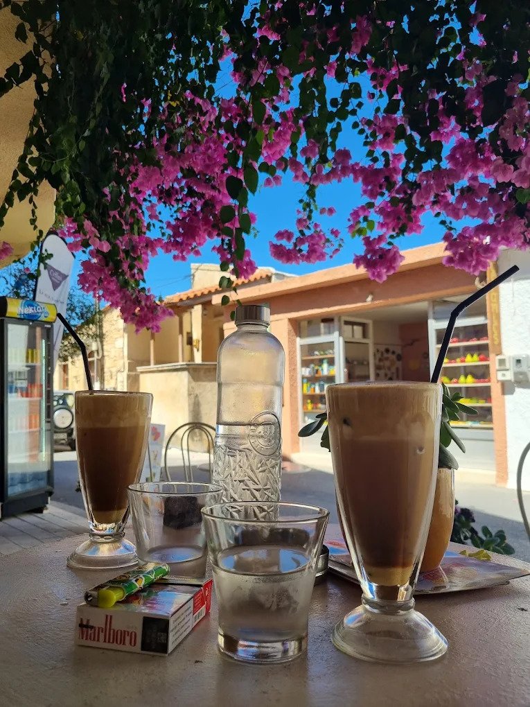 Morning rituals in Margarites: freddo coffee, good company, and bougainvillea in full bloom at Sweet Margarita's Bakery, Rethymno.
