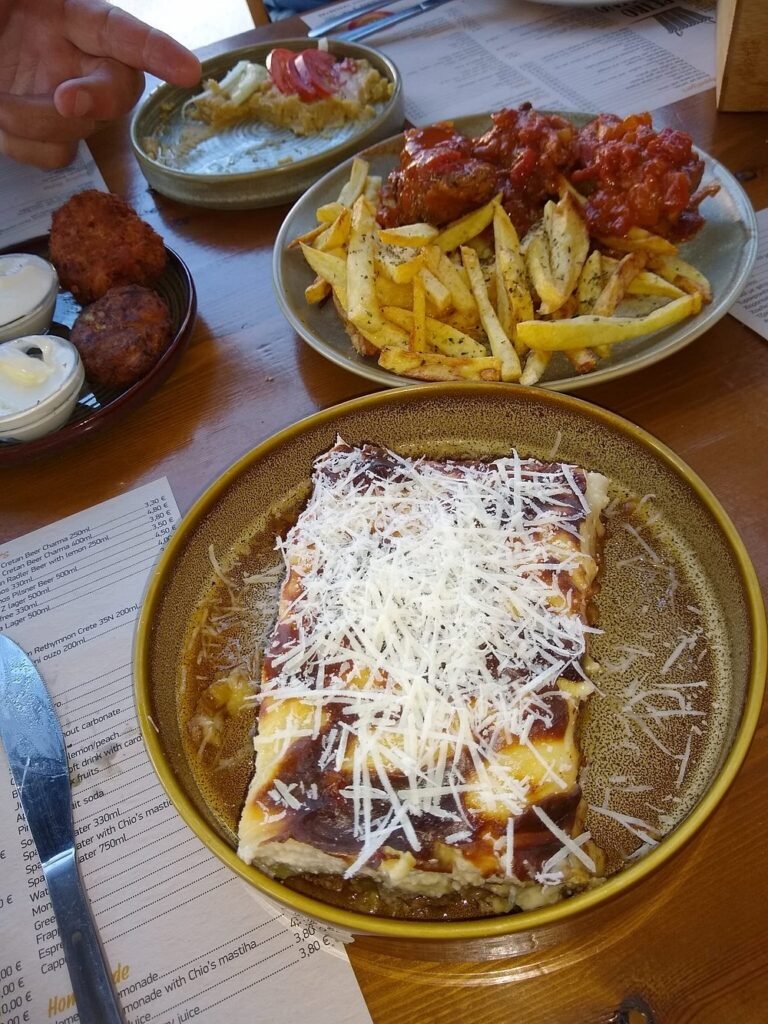 A delicious stop on your Crete road trip — Petrokofino in Spili serves up local favourites like baked moussaka, crispy fries, and soutzoukakia (Greek meatballs) in rich tomato sauce. The perfect spot to recharge before hitting the road again. 
