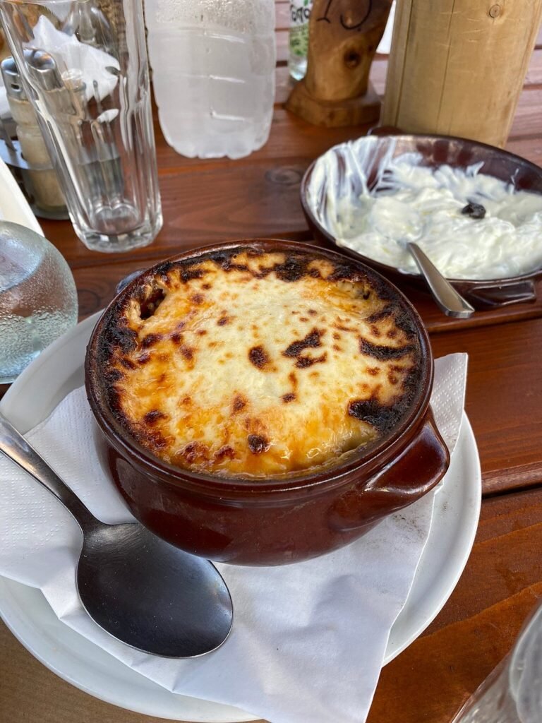 Comforting, oven-baked moussaka served with love at Frosinis Garden, where village hospitality meets home-style cooking.