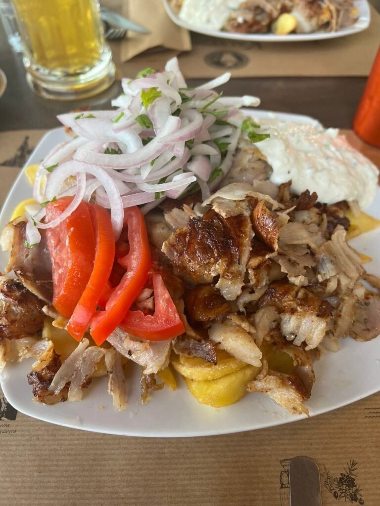 Pork gyros served with tzatziki, tomatoes, onions, and fries at Kalypso Taverna in Kaloudiana, Chania.