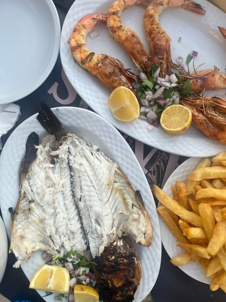 A fresh seafood feast at Manos Fish Taverna, loved for its grilled fish, giant prawns, and generous portions.