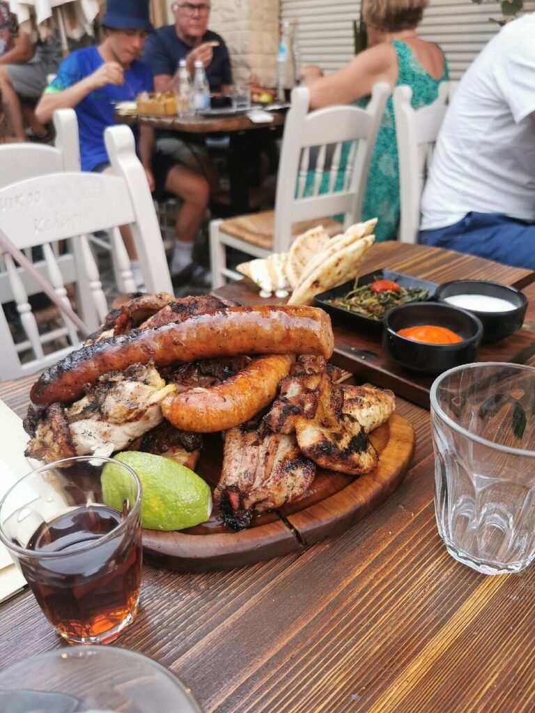 Grilled to perfection—Mikro Kelari in Chania Town serves generous meat platters with a side of raki and lively atmosphere.