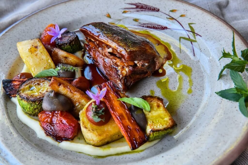 Goat shoulder cooked in a wood oven, served with caramelized vegetables at Milia Mountain Retreat, Crete, Greece.