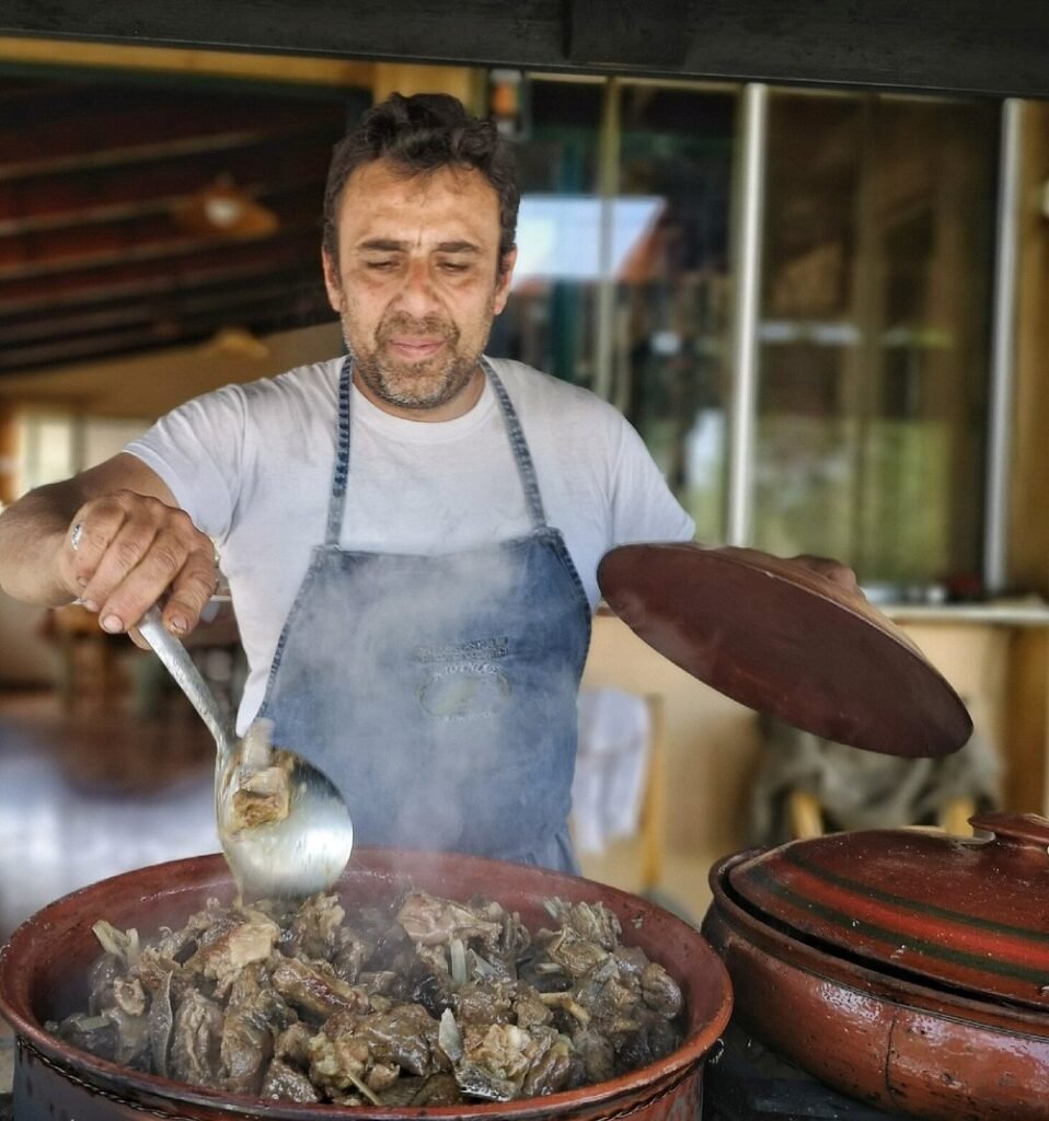 Stelios Trilirakis preparing goat stew in a clay pot at Ntounias Taverna, Drakona.