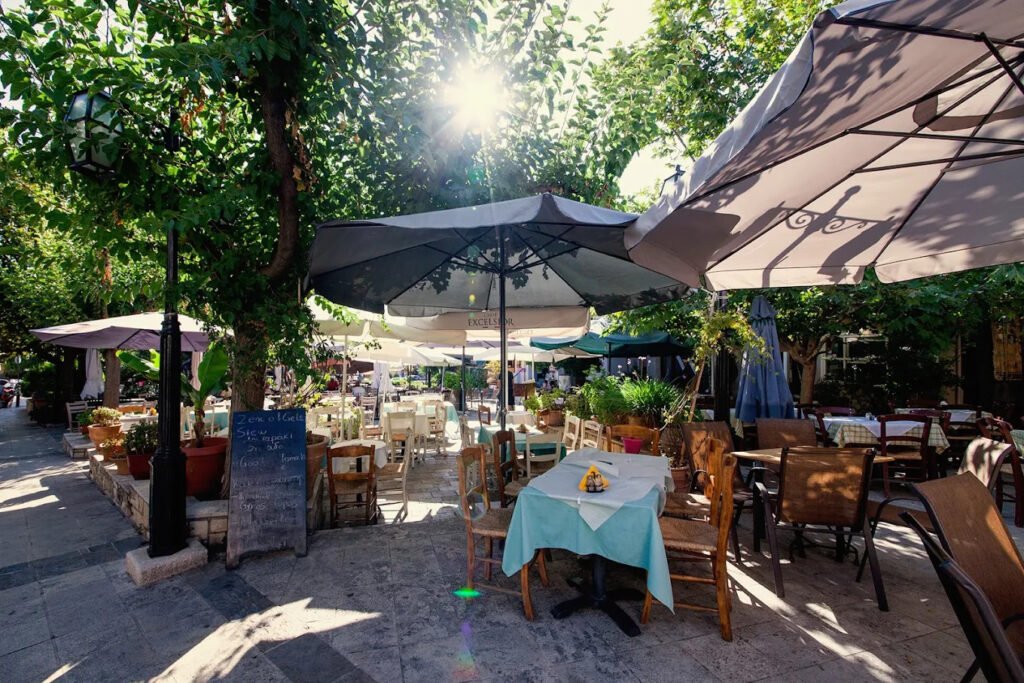 At Zen of Crete in Archanes, outdoor seating under lush greenery creates a tranquil setting for enjoying authentic Cretan cuisine and the village’s relaxed charm. Photo Credit: Zen of Crete.