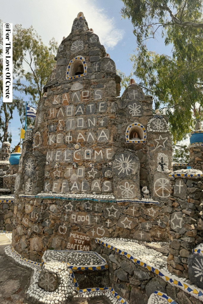 The welcoming stone tower at Monumento Kefalas displays multilingual greetings and religious symbols, representing artist Vangelis Vlepakis's vision of universal hospitality and spiritual unity in Crete.