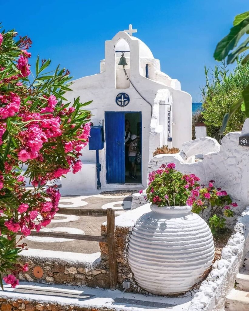 A small chapel at Lychnostatis Open-Air Museum showcases authentic Cretan religious architecture surrounded by vibrant bougainvillea and classic pottery, bringing Crete's spiritual heritage to life.
