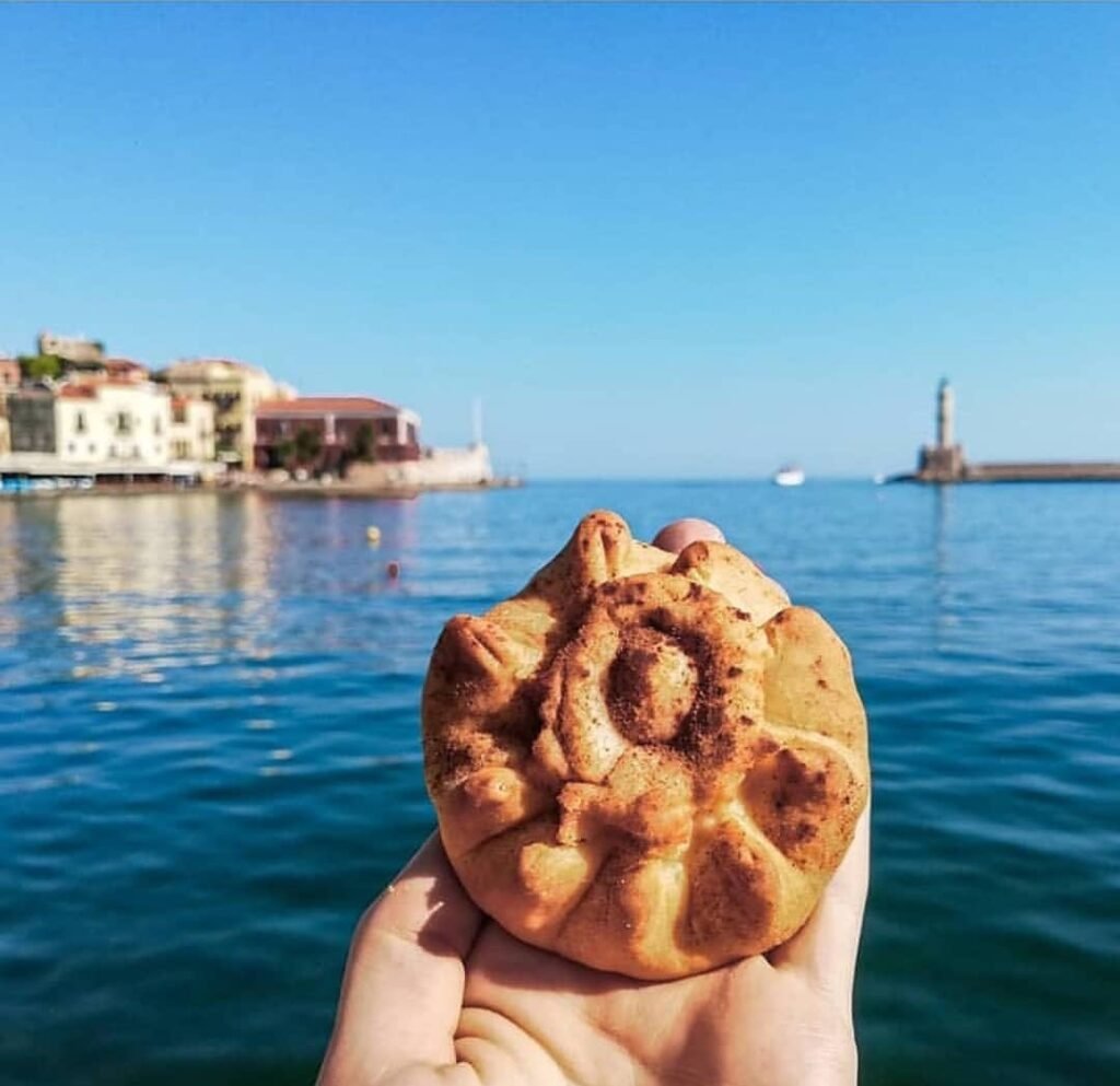 Delicate kalitsounia shaped like flowers and filled with sweet cheese, dusted with cinnamon for a charming traditional Cretan treat. 