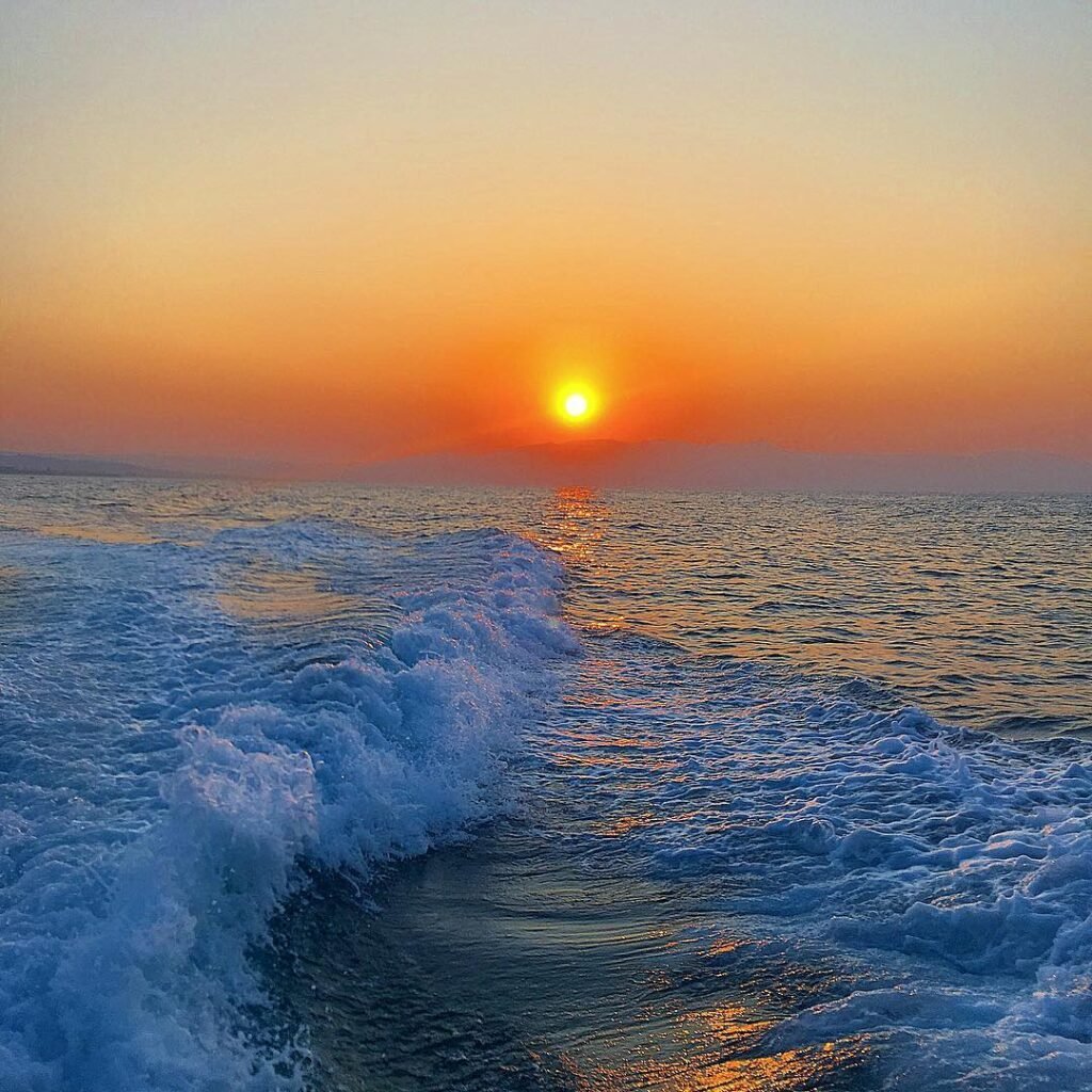 Golden sunset at Platanias Beach in Chania, where Crete's legendary "light of the gods" creates the perfect conditions for natural heliotherapy. 