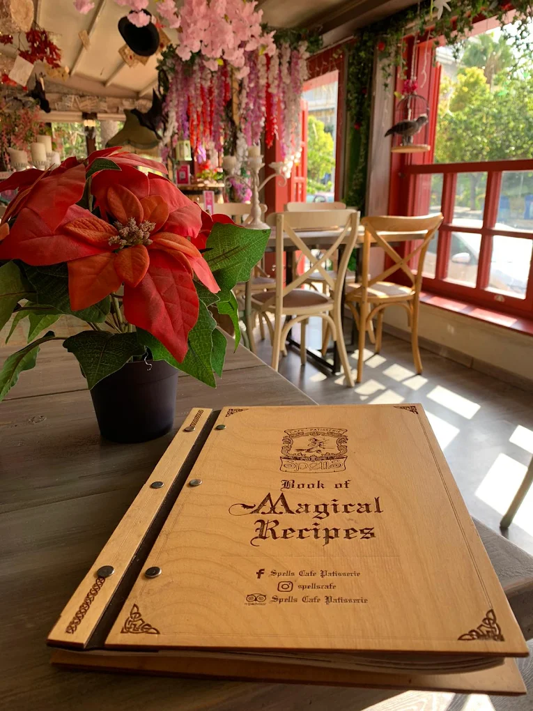 The enchanting fairytale atmosphere at Spells Café Patisserie, where the "Book of Magical Recipes" menu and whimsical décor featuring Beauty and the Beast, Harry Potter, and Snow White elements create a truly immersive experience in Heraklion's city center.