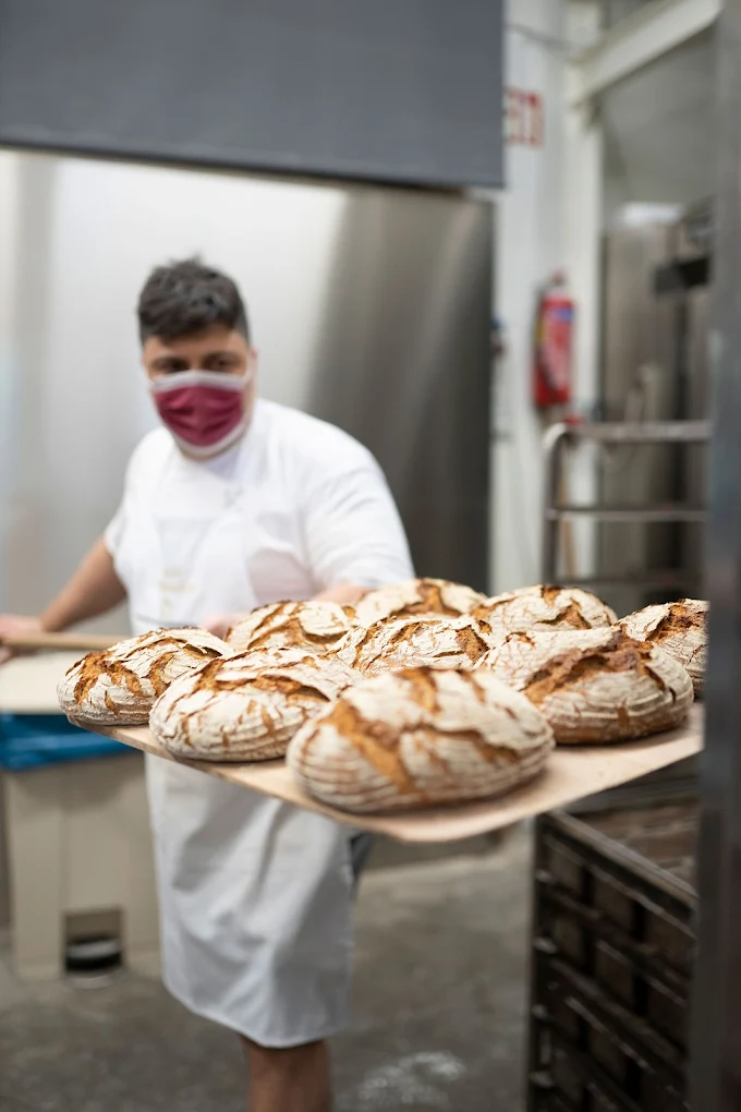Freshly baked sourdough loaves straight from the oven at Bakery Plakopoulos, where third-generation bakers in Chania continue traditional bread-making techniques that have earned this bakery a devoted following since 1922. Photo Credit: Bakery Plakopoulos