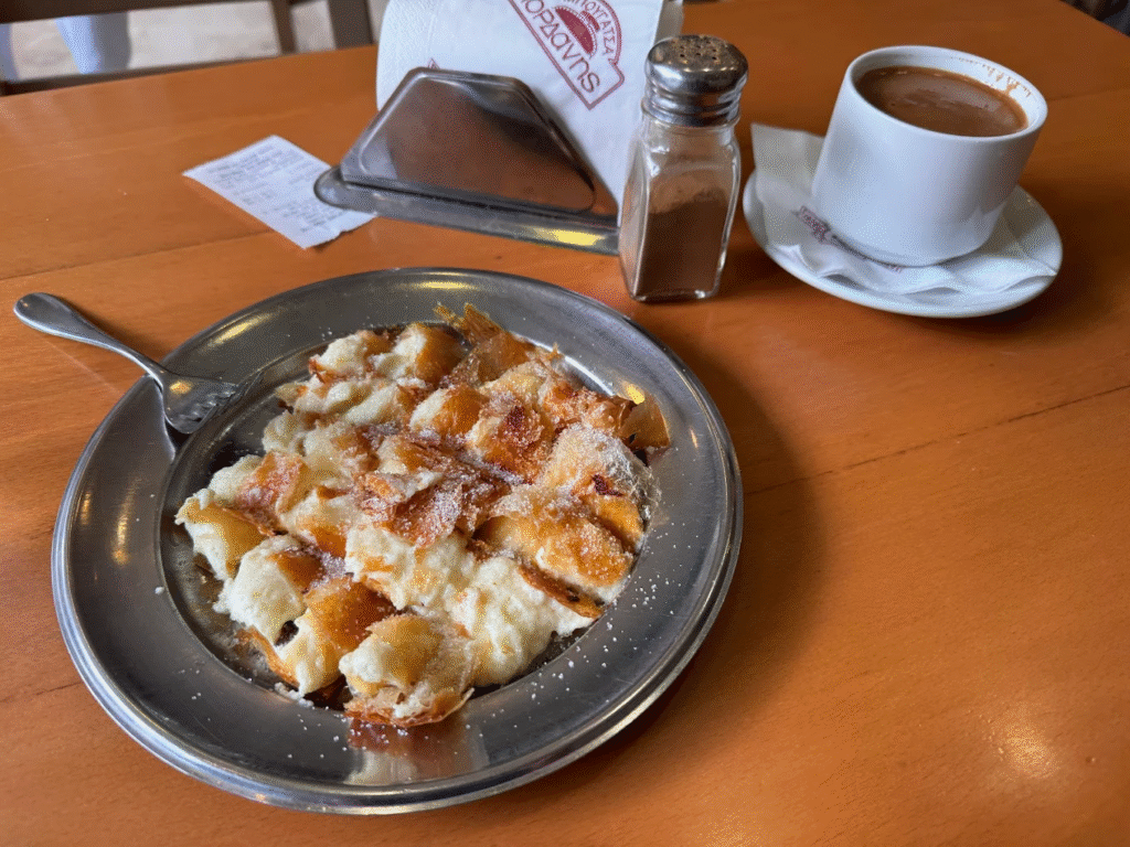 Fresh bougatsa with crispy phyllo dusted with powdered sugar and cinnamon at Bougatsa Iordanis, one of the most iconic bakeries in Chania operating since 1924. 