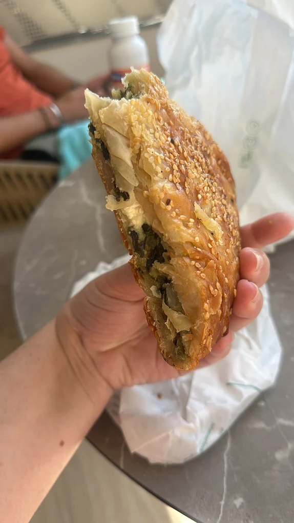 A freshly baked spanakopita from Markos & Niki Dourountakis Sfakian Bakery showcasing the flaky, golden phyllo layers and spinach filling that makes this traditional Cretan pie a must-try in Chora Sfakion. Photo Credit: Marta