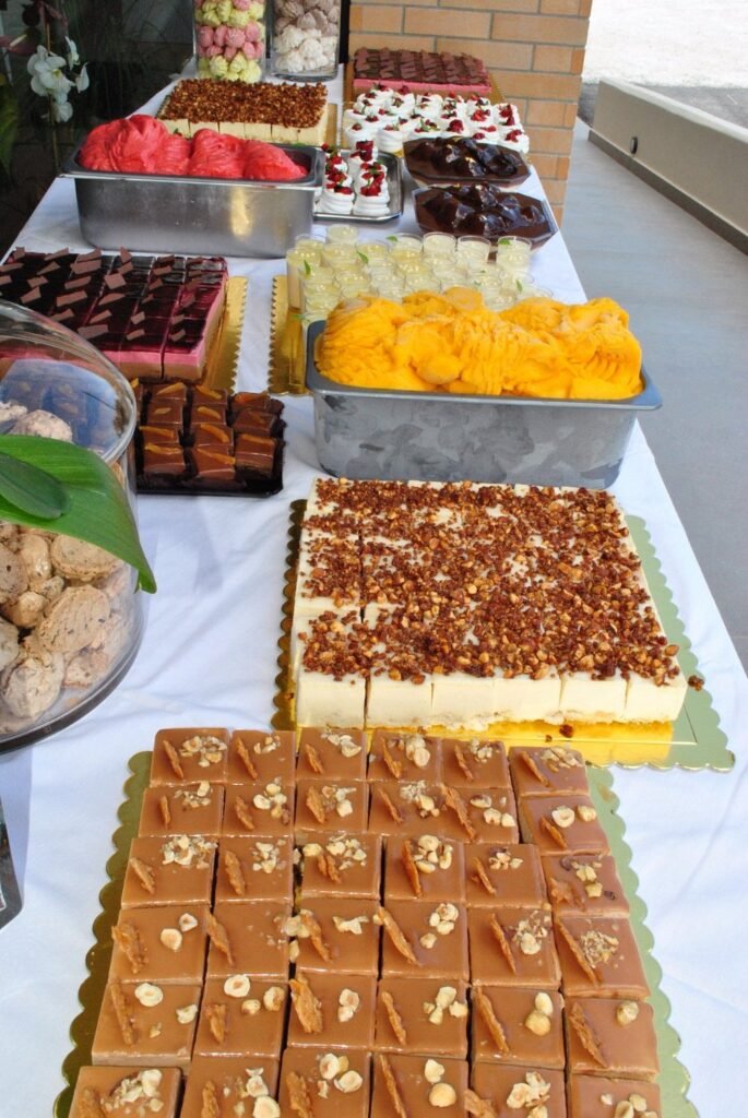 An impressive array of desserts at Oneira Glyka, one of Chania's top-rated bakeries, featuring handmade chocolate squares, layered cream cakes with crushed nuts, strawberry tarts, and colorful meringues that showcase the patisserie's dedication to variety and quality. Photo Credit: Pantelis F.