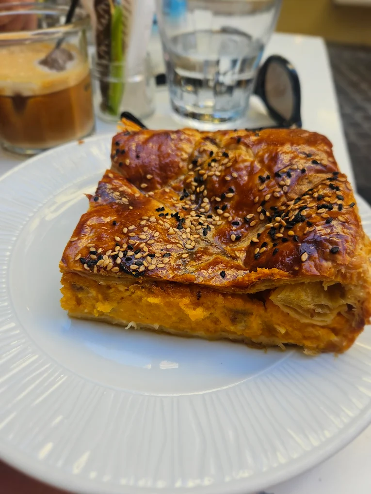 A savory handmade phyllo pastry from Phyllo Chania topped with sesame and nigella seeds, showcasing the golden, flaky layers and creative fillings that have made this Old Town bakery a beloved destination for craft baking using local Cretan ingredients. Photo Credit: Georgia Vardaki